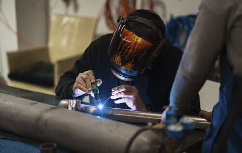 mecânico demonstrando como usar máquina de solda
