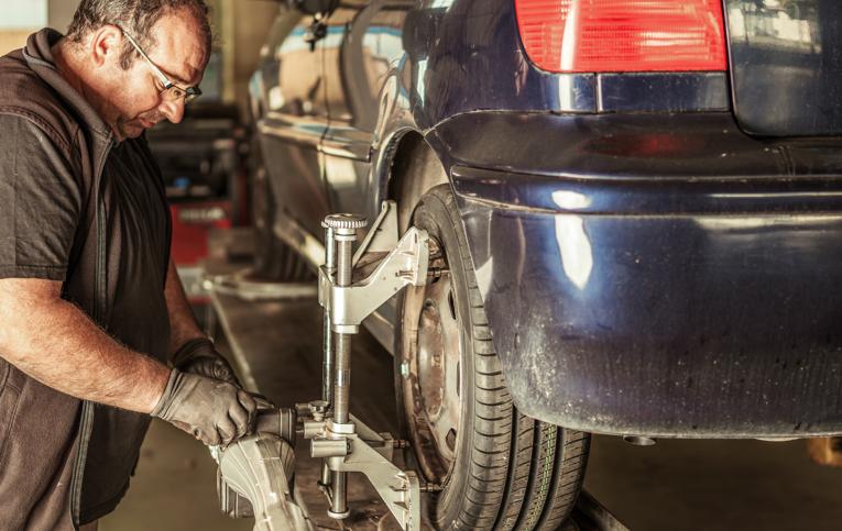 mecânico apertado equipamento em pneu de automóvel demonstrando como alinhar carro