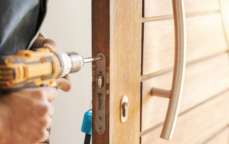 pessoa usando parafusadeira de impacto para apertar parafusos de uma porta representando como recuperar porta de madeira