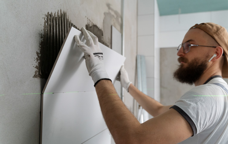 Pedreiro mostrando como colocar azulejo na parede