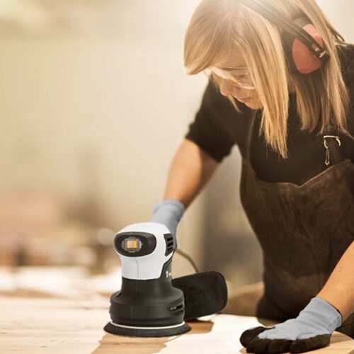 Uso de lixadeira orbital em acabamento de madeira, demonstrando aplicação prática e diferença entre lixadeira orbital e lixadeira roto orbital para trabalhos de lixamento fino.