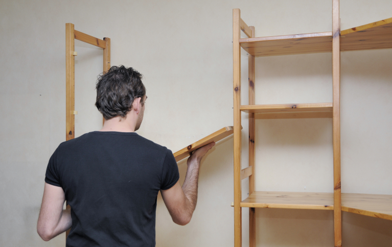 Homem montando estante de madeira